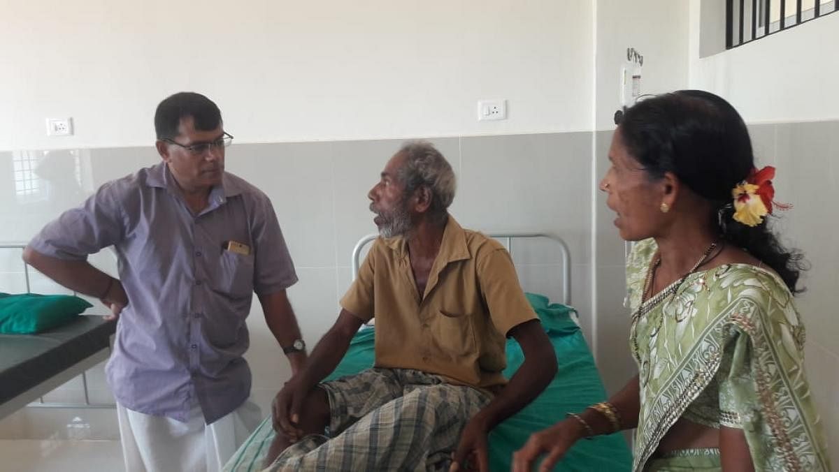 Human rights activist Prashanth D’Costa speaks to 75-year-old Ramanna Gowda at a hospital in Kadaba on Tuesday.