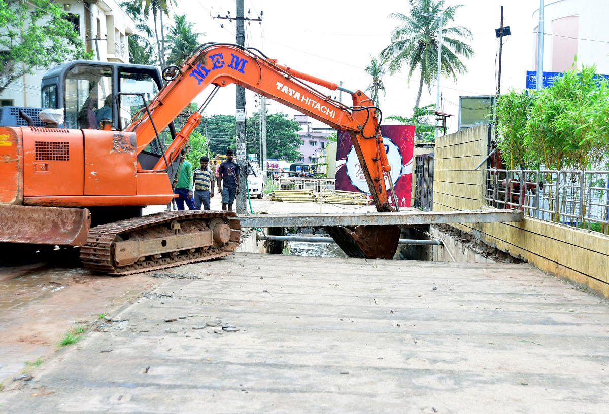 Men in action at the encroachment clearance drive undertaken at Kottara Chowki in Mangaluru on Monday. DH PHOTO