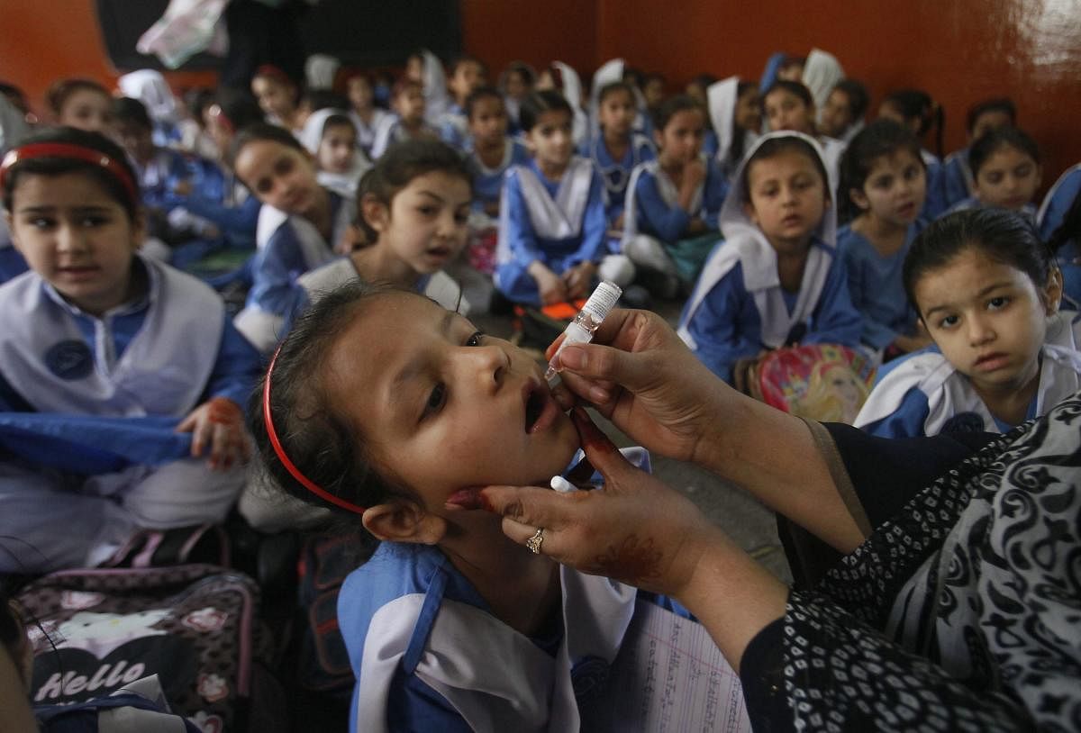 A health worker gives a polio vaccination to students in Peshawar, Pakistan. (AP/PTI Photo)
