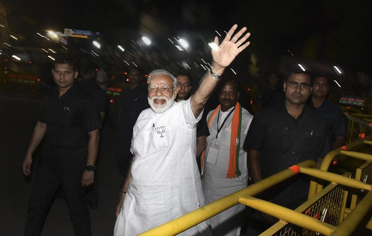 Ranchi: Prime Minister Narendra Modi waves at supporters during a roadshow in support of BJP's Ranchi constituency candidate Sanjay Seth for Lok Sabha elections, in Ranchi, Tuesday, April 23, 2019. Jharkhand Chief Minister Raghubar Das is also seen. (PTI