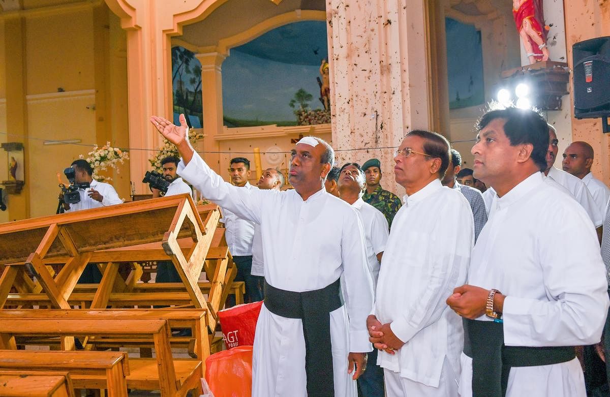 This handout photo taken and released by the Sri Lankan President's Office on April 23, 2019 shows President Maithripala Sirisena (2nd R) visiting St. Sebastian's church in Negombo, two days after a series of bomb attacks targeting churches and luxury hot