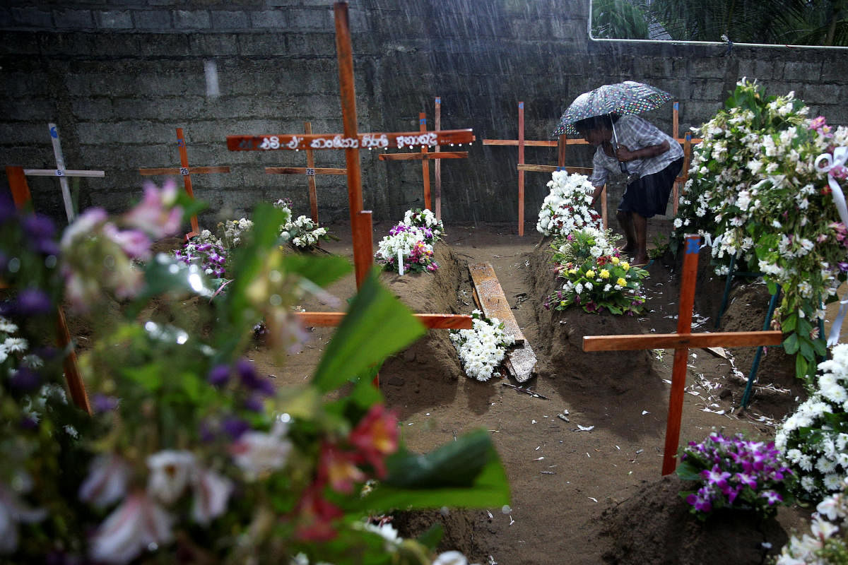 A woman comes to the site of a mass burial to pay her respects to victims of a string of suicide bomb attacks on churches and luxury hotels on Easter Sunday, in Negombo, Sri Lanka April 25, 2019. REUTERS/Athit Perawongmetha