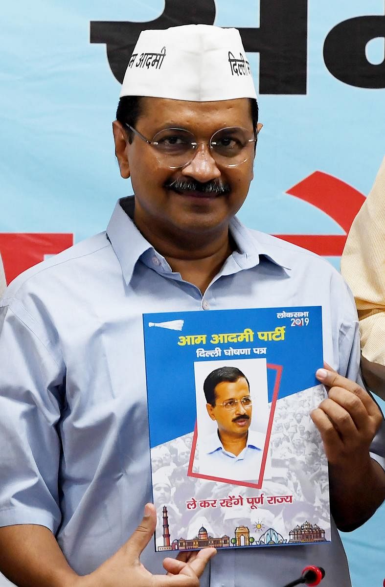 Chief Minister of Delhi Arvind Kejriwal looks on as he poses with a copy of the Aam Aadmi Party election manifesto at the party headquarters in New Delhi on April 25, 2019. (AFP)