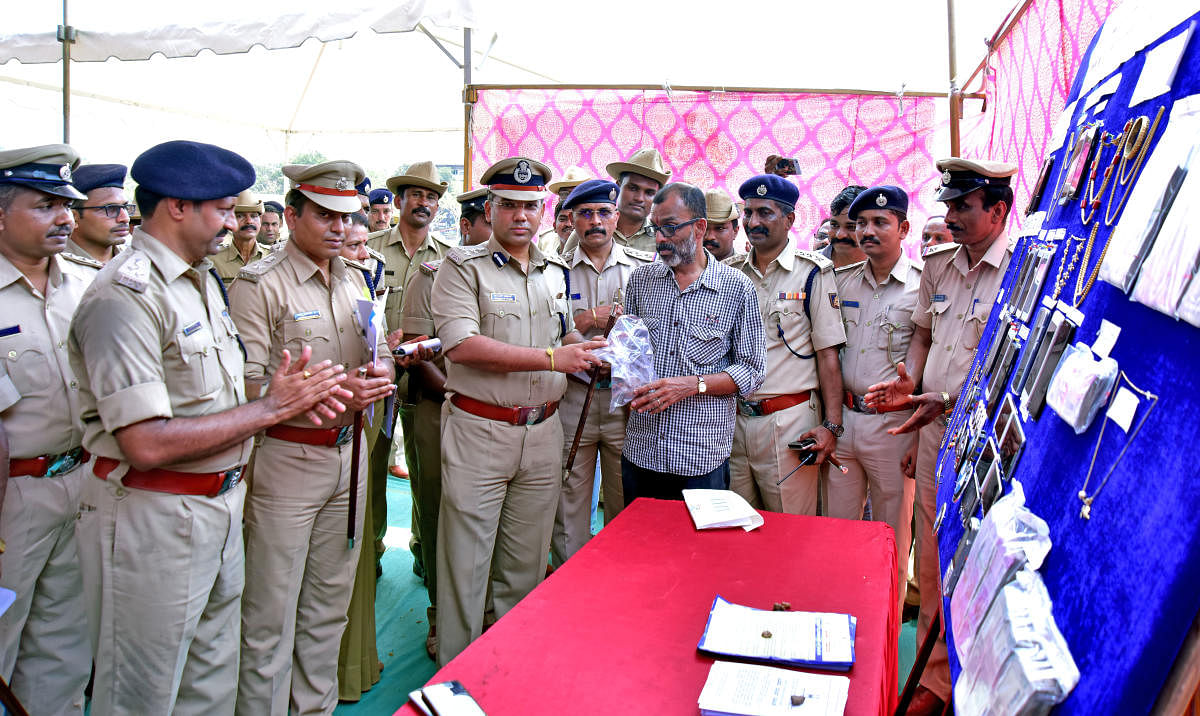 City Police Commissioner Sandeep Patil returns a recovered stolen property to an owner, at a property parade held at Nehru Maidan in Mangaluru on Friday. 