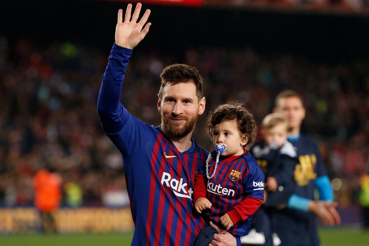 Barcelona's Argentinian forward Lionel Messi holds his son Ciro as he celebrates after Barcelona won their 26th league title at the end of the Spanish League football match between Barcelona and Levante at the Camp Nou stadium in Barcelona. AFP