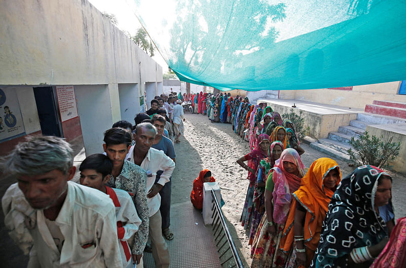 People wait in queues to cast their vote at a polling station at Sirohi district in Rajasthan. (Reuters Photo)