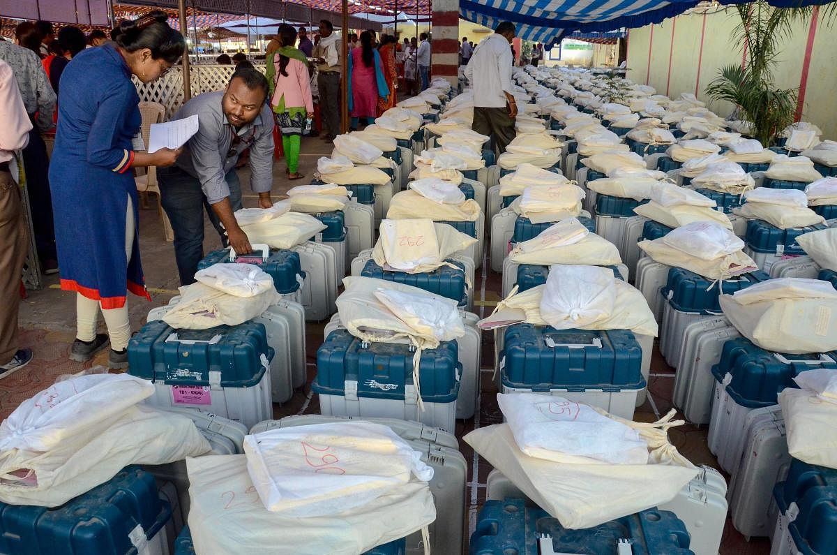 Poll officials collect Electronic voting machines (EVM) and other material from an EVM distribution centre on the eve of the 4th phase of Lok Sabha elections, in Jabalpur. (PTI Photo)