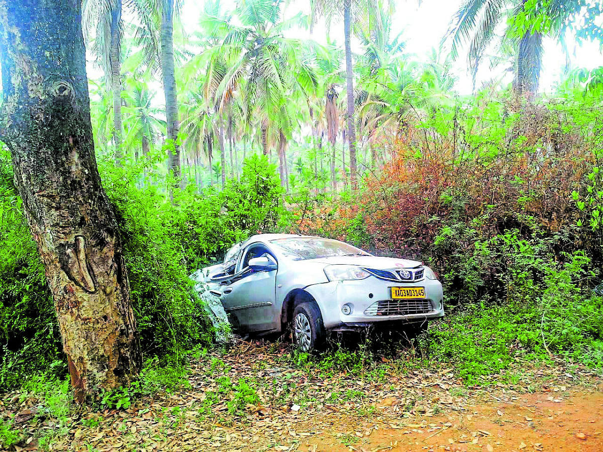 The car that crashed into a rodside tree near KB Cross in Tiputur taluk, Tumakuru district, on Monday.
