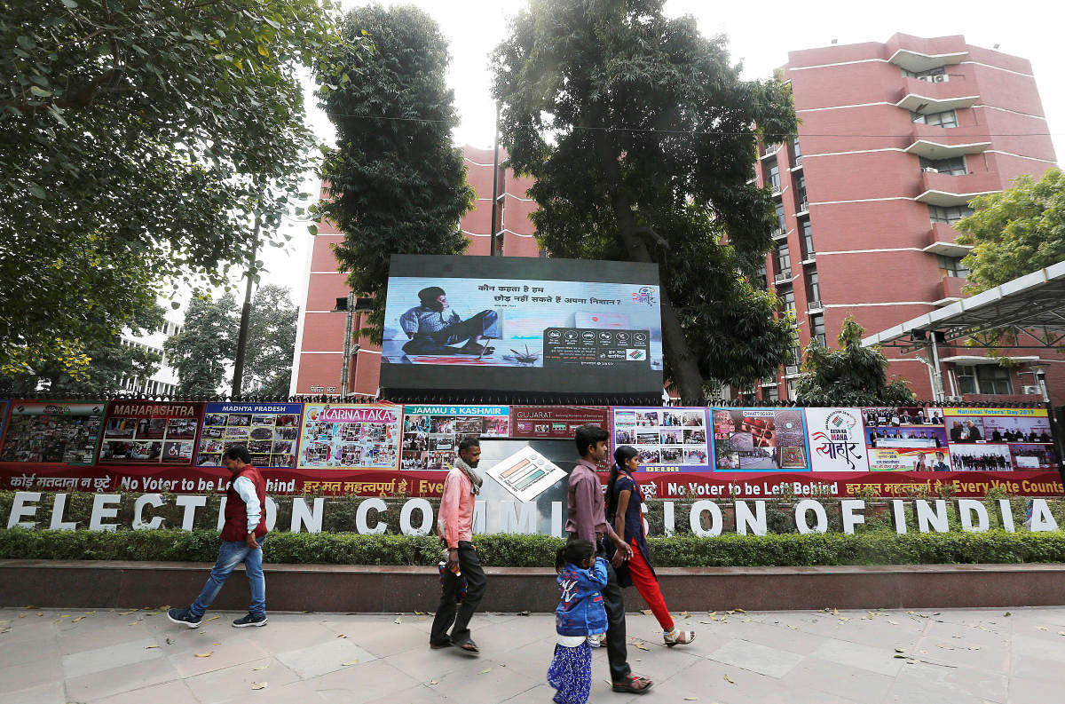 FILE PHOTO: People walk past the Election Commission of India office building in New Delhi, India March 11, 2019. REUTERS/Adnan Abidi/File Photo