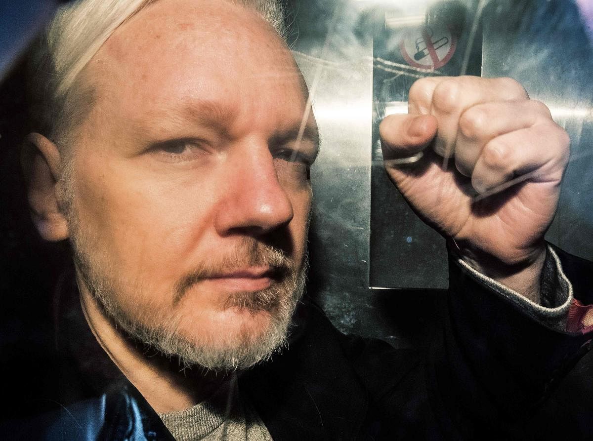 WikiLeaks founder Julian Assange gestures from the window of a prison van as he is driven into Southwark Crown Court in London on May 1, 2019, before being sentenced to 50 weeks in prison for breaching his bail conditions in 2012. AFP