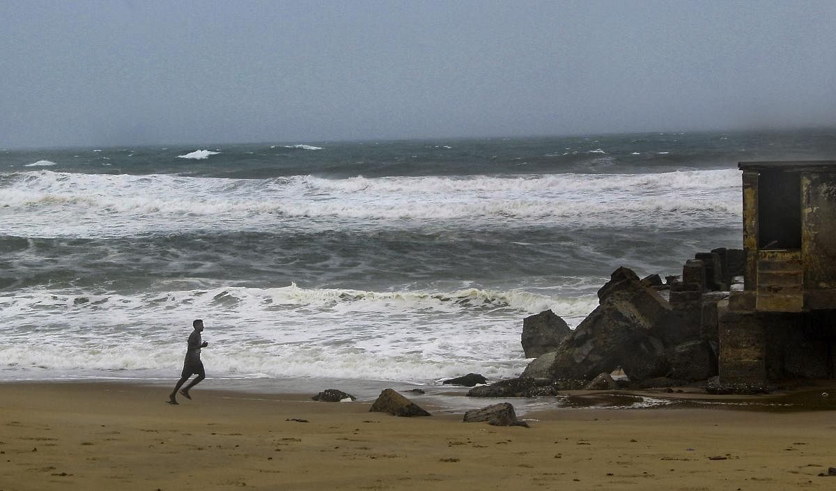 A fisherman runs as he ensures to check the safety of fishing boats docked on the beach amidst stormy weather, before Cyclone Fani makes landfall, in Puri, Odisha. PTI Photo