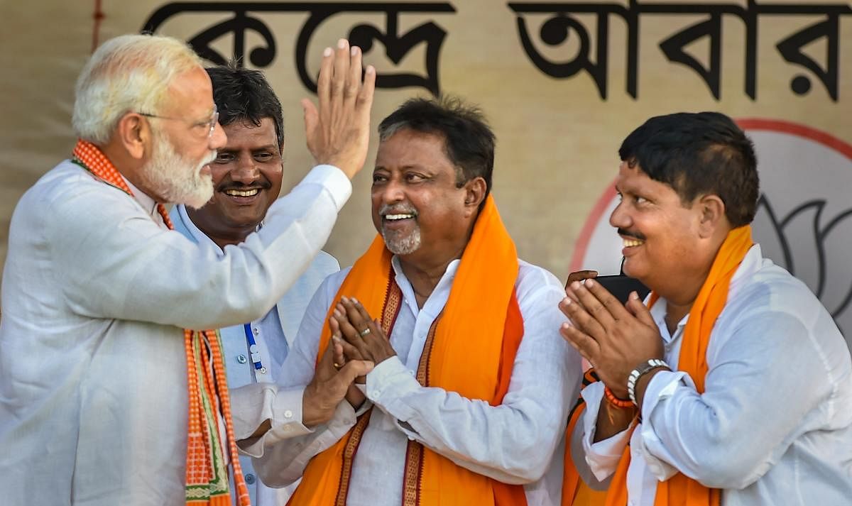 Prime Minister Narendra Modi being greeted by BJP leader Mukul Roy and party candidate from Barrackpore constituency Arjun Singh (R) during an election campaign rally for ongoing Lok Sabha polls, at Jilebi in North 24 Parganas district of West Bengal on April 29, 2019. (PTI Photo)