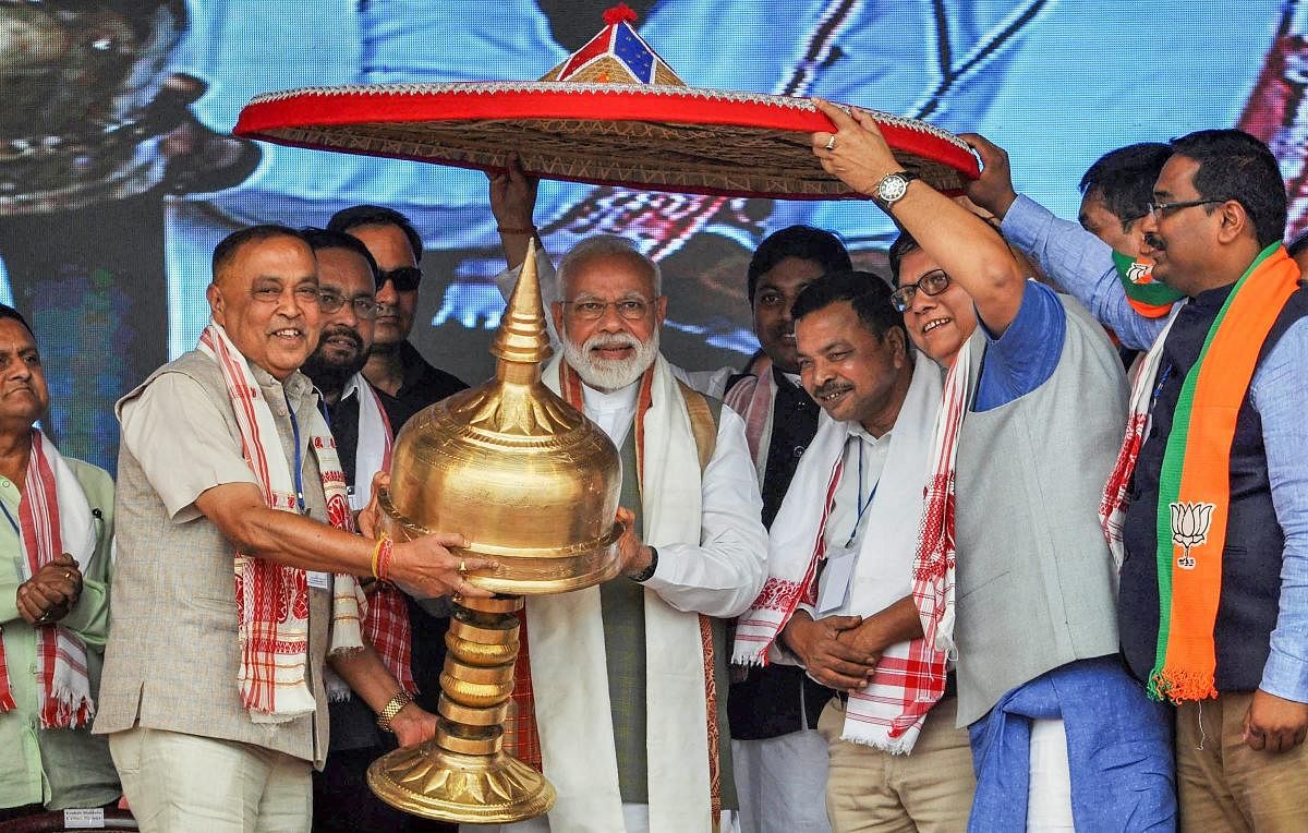 Prime Minister Narendra Modi being felicitated by his party leaders during an election rally ahead of Lok Sabha elections, at Gohpur, in Biswanath district, on Saturday. (PTI Photo)