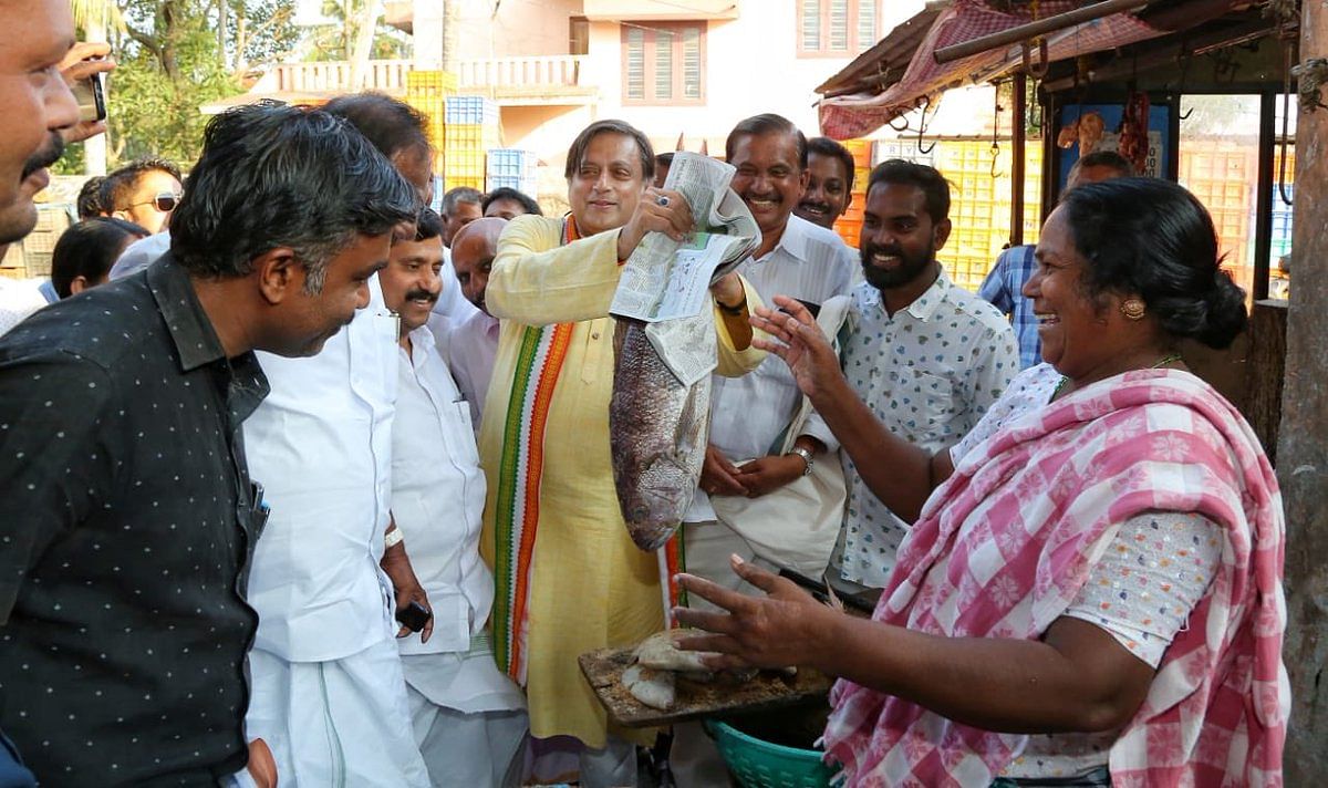 Congress candidate for Thiruvananthapuram Lok Sabha constituency Shashi Tharoor holds a fish at a fish market in the city. (Twitter/Shash Tharoor)