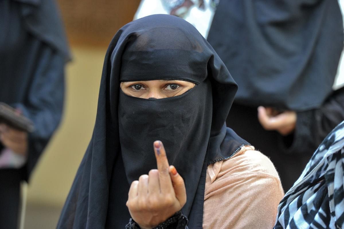 A Muslim shows her ink-marked finger after casting her vote at a polling station in Kurnool district, Andhra Pradesh. AFP