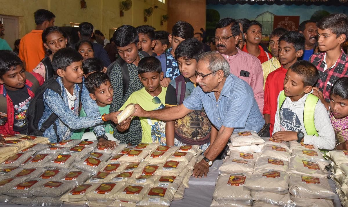 Environmentalist Nagesh Hegde with children at the millet mela in Lalbagh on Friday. DH PHOTO/S K DINESH