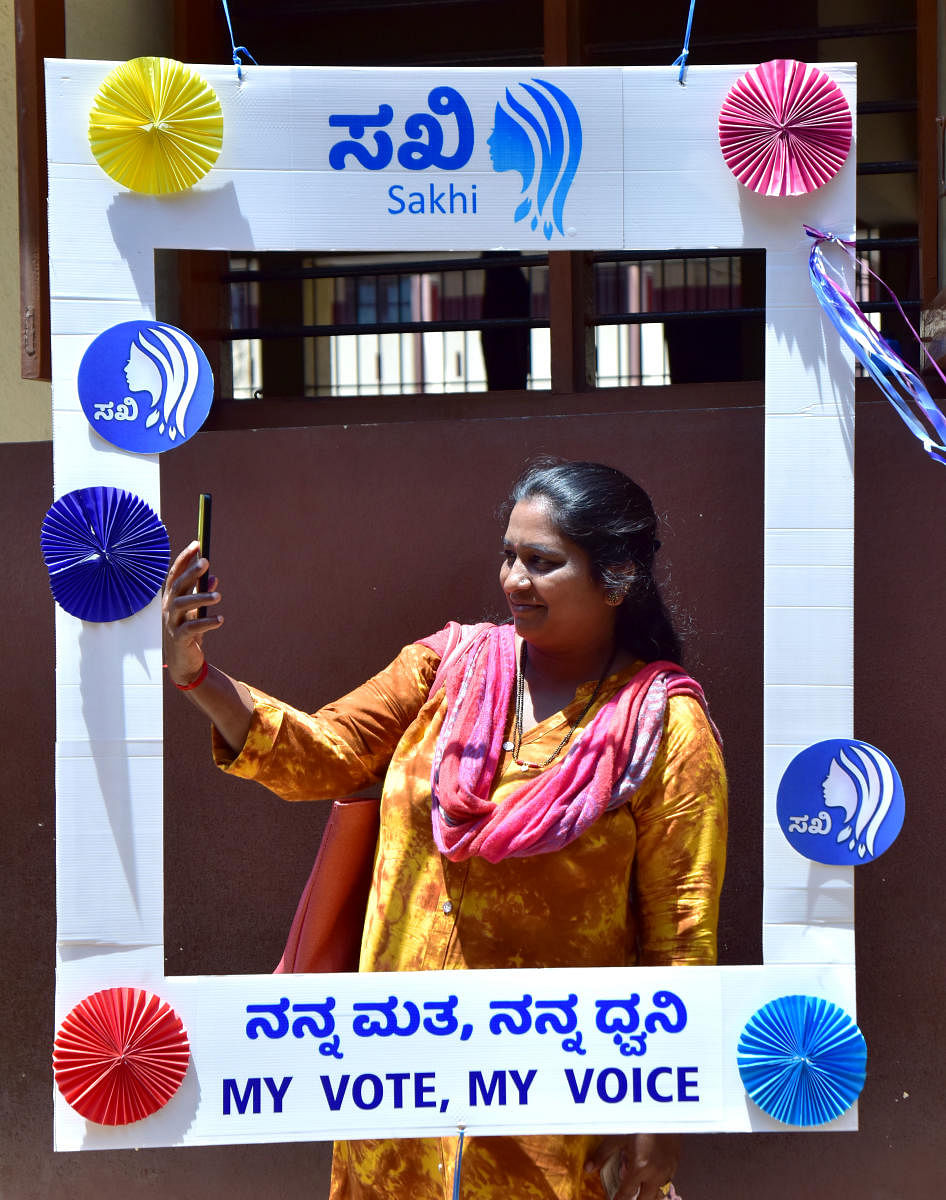 A woman is seen clicking a selfie at the selfie corner put up near Sakhi Polling Booth in Mangaluru on Thursday.