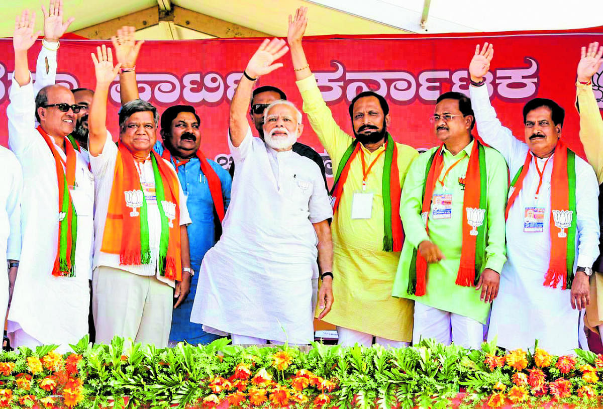 Prime Minister Narendra Modi greets at the crowd during Vijay Sankalp Yatra rally in Chikkodi, Belagavi district, on Thursday. (from left) BJP leaders Prabhakar Kore, Jagadish Shettar, Lakshman Savadi, party nominee from Chikkodi Annasaheb Jolle and Belag