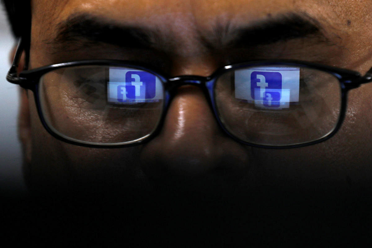 FILE PHOTO: Facebook logo is reflected in glasses in this picture illustration taken April 1, 2019. REUTERS/Akhtar Soomro/Illustration/File Photo