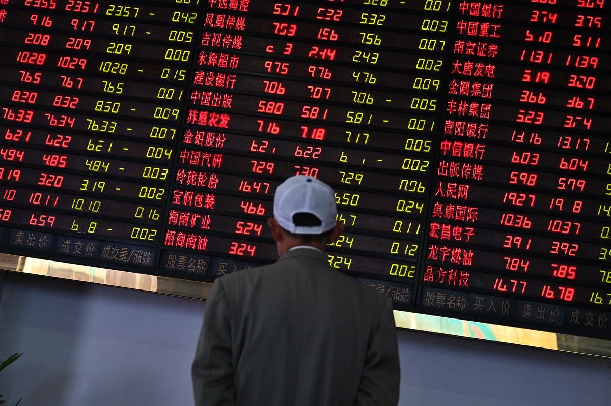 Investors monitor stock price movements at a securities company in Shanghai on May 8, 2019. - A red wave swept across Asia trading floors, as investors grow increasingly concerned that the China-US trade deal, which appeared all by ready to sign, could fa