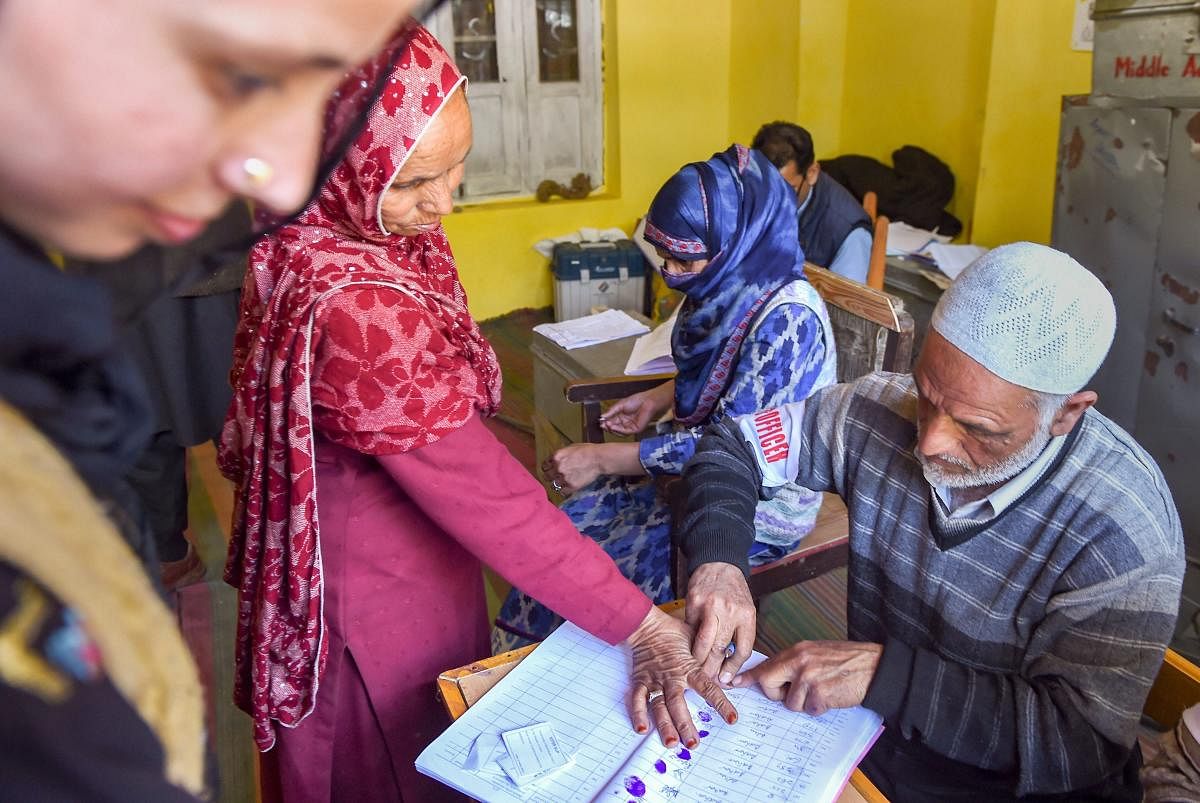 An elderly voter puts her thumb impression before casting her vote at a polling station during the third phase of Lok Sabha elections, in Anantnag on April 23, 2019. PTI