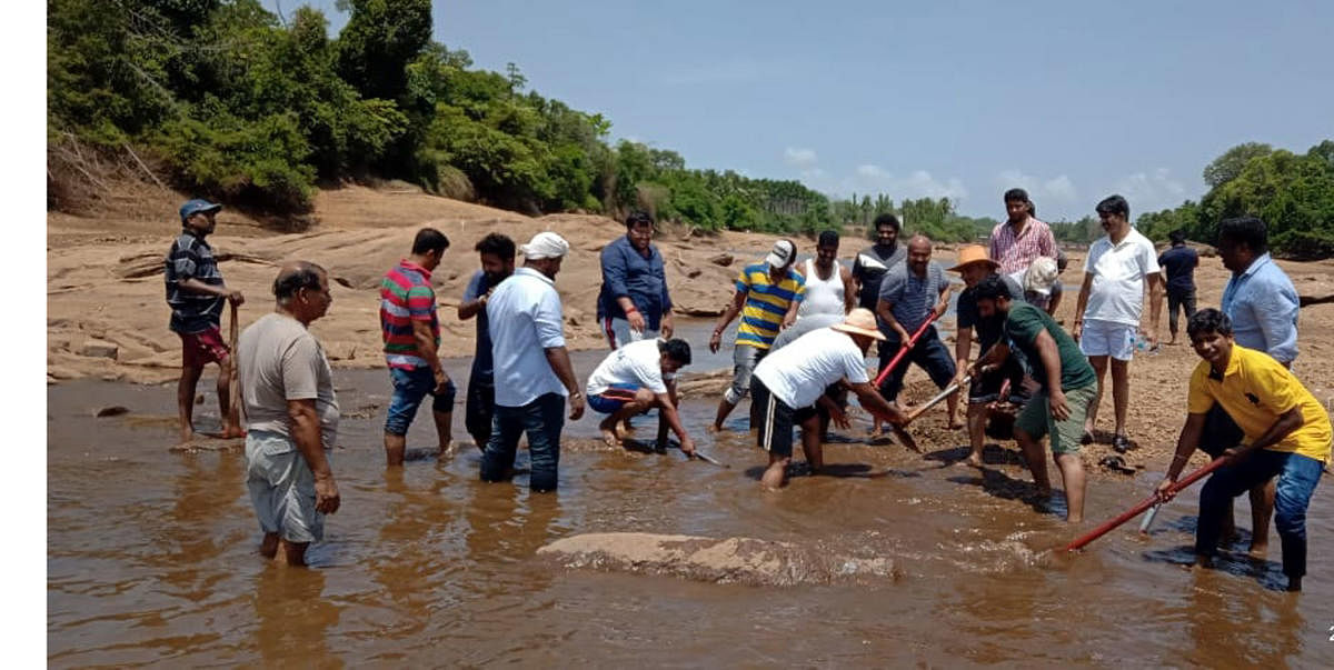 MLA Raghupathi Bhat joins hands with volunteers as part of Shramadan to desilt River Swarna to ensure free flow water, near Baje reservoir on Thursday.