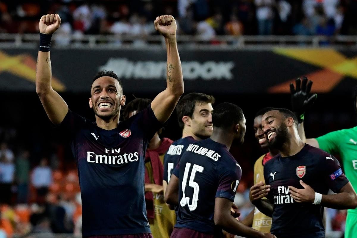 Arsenal's Gabonese striker Pierre-Emerick Aubameyang (L) celebrates with teammates at the end of the UEFA Europa League semi-final second leg football match between Valencia CF and Arsenal FC at the Mestalla stadium in Valencia on May 9, 2019. (Photo by J