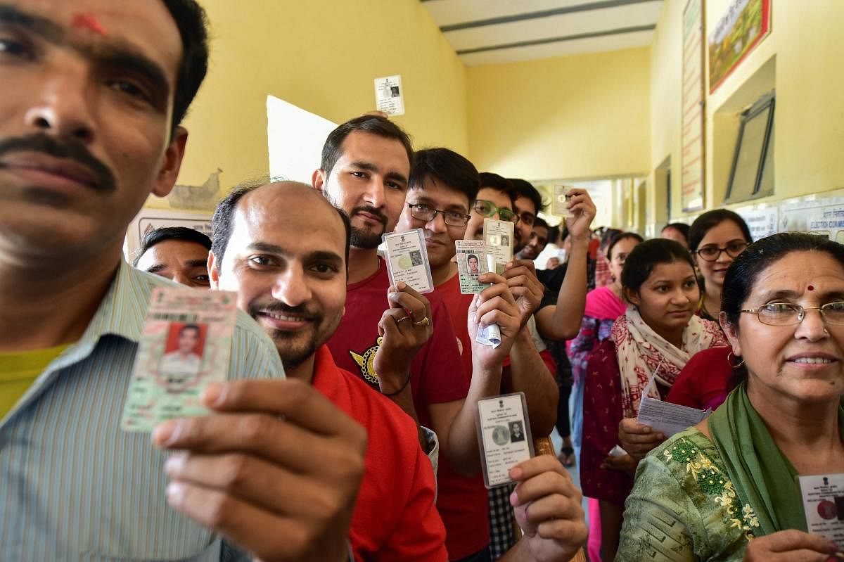 Voters wait outside a polling booth to cast their votes during the sixth phase of Lok Sabha elections 2019, at Baprola Nangloi, in West Delhi, Sunday, May 12, 2019. (PTI Photo)
