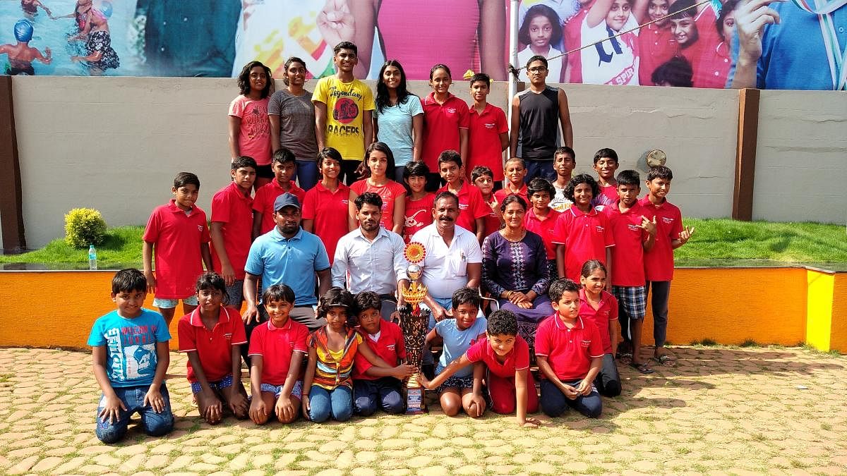 Team members and coaches of Jai Hind Swimming Club, which bagged first place in inter-district swimming competition, with their trophy in Mangaluru. DH photo   