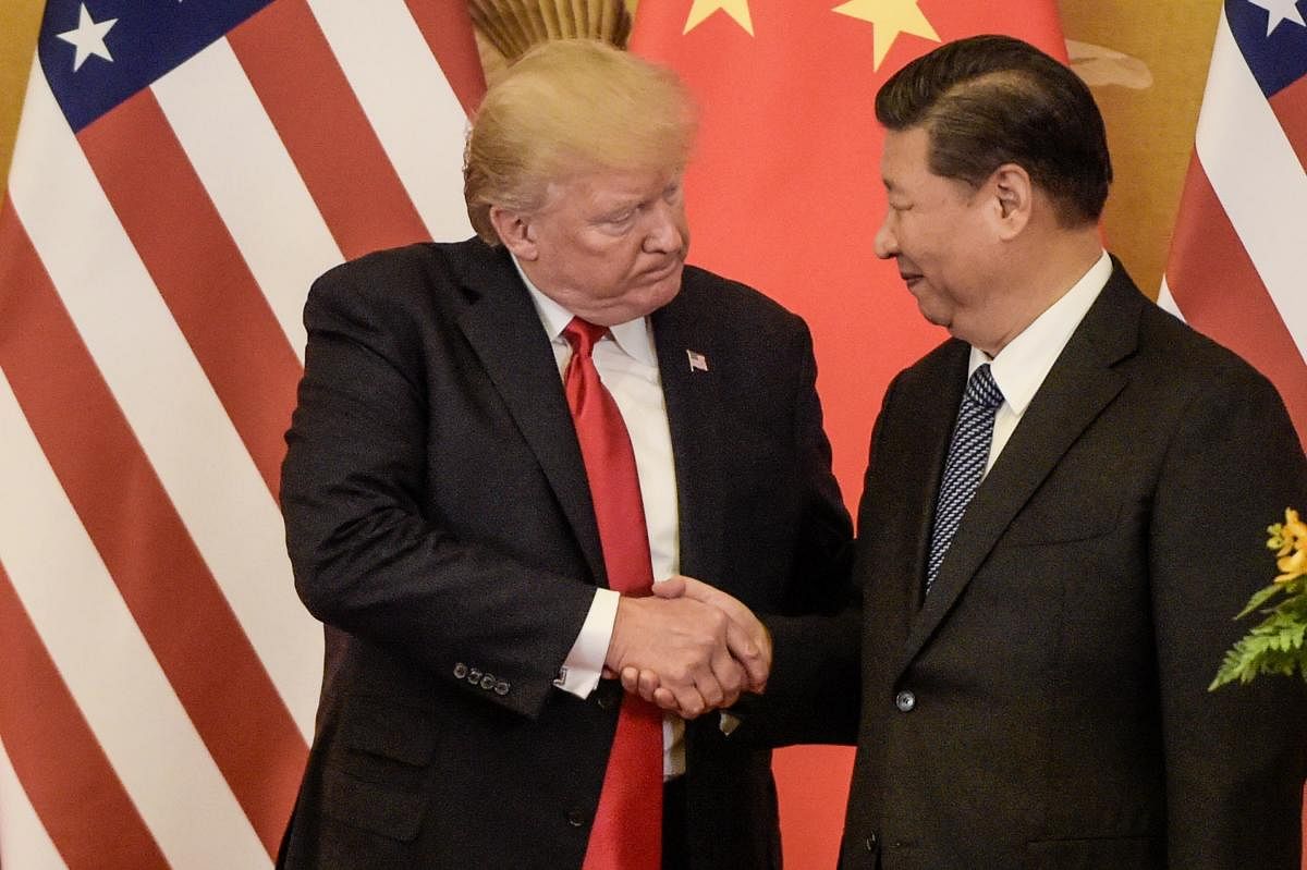 (FILES) In this file photo taken on November 09, 2017, US President Donald Trump (L) shakes hand with China's President Xi Jinping at the end of a press conference at the Great Hall of the People in Beijing. - China said Monday, May 13, 2019 it will raise