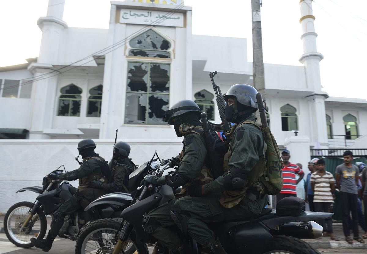 Heavily-armed Sri Lankan soldiers ride a motorcycle in front of the Jumha Mosque after a mob attack in Minuwangida. (AFP File Photo)