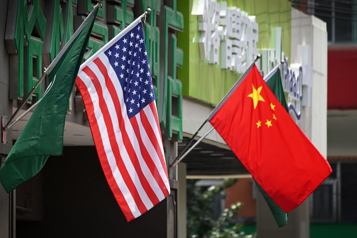 The US (L) and Chinese flags are displayed outside a hotel in Beijing on May 14, 2019. - Beijing's latest retaliation against US tariff hikes -- an increase on $60 billion of US imports from June 1 -- could leave China running low on ammunition in the tra