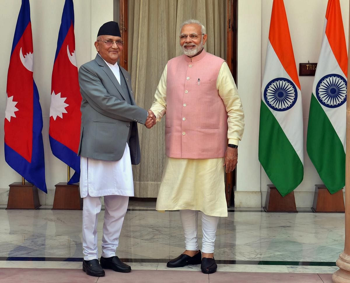 Prime Minister Narendra Modi shakes hands with his Nepalese counterpart Khadga Prasad Oli before their meeting at Hyderabad House in New Delhi on Saturday. (PTI Photo)