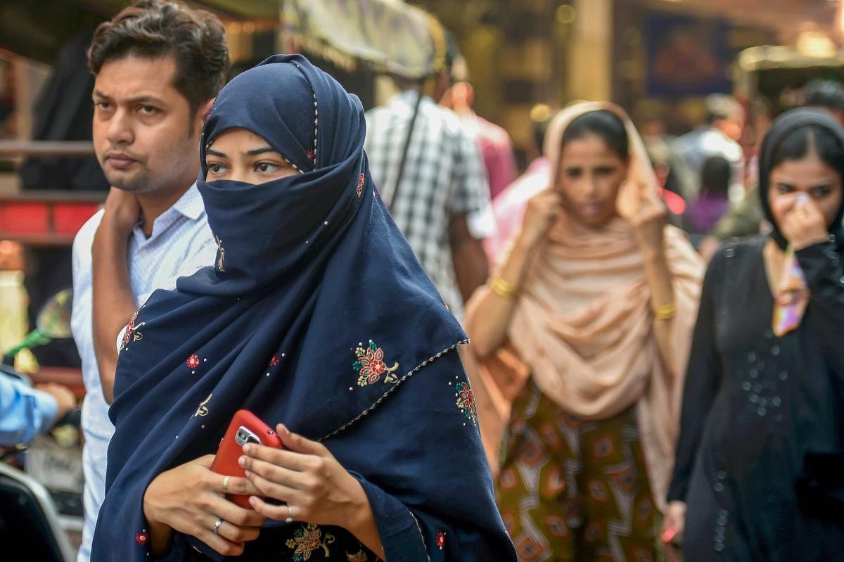 A Muslim woman walks in a market near the Jama Masjid in New Delhi on Wednesday. (PTI)