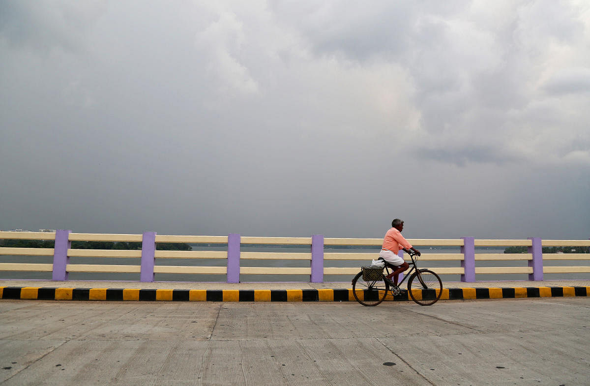 A man rides his bicycle across a bridge as pre-monsoon clouds gather over the Vembanad Lake in Kochi, India, May 8, 2018. (REUTERS File Photo)