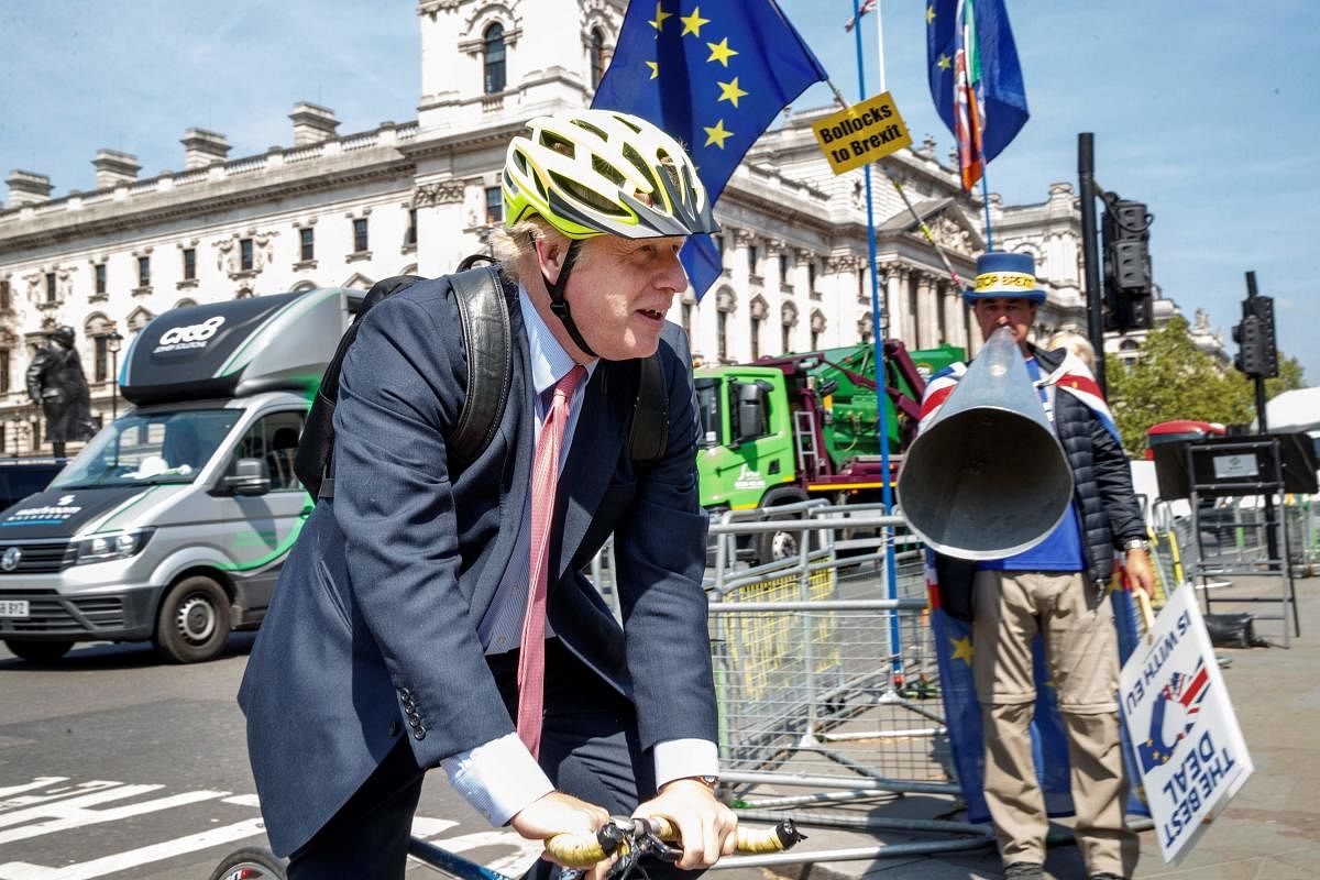 Pro-Brexit Conservative MP Boris Johnson rides his bicycle as he arrives at the Houses of Parliament in London. AFP