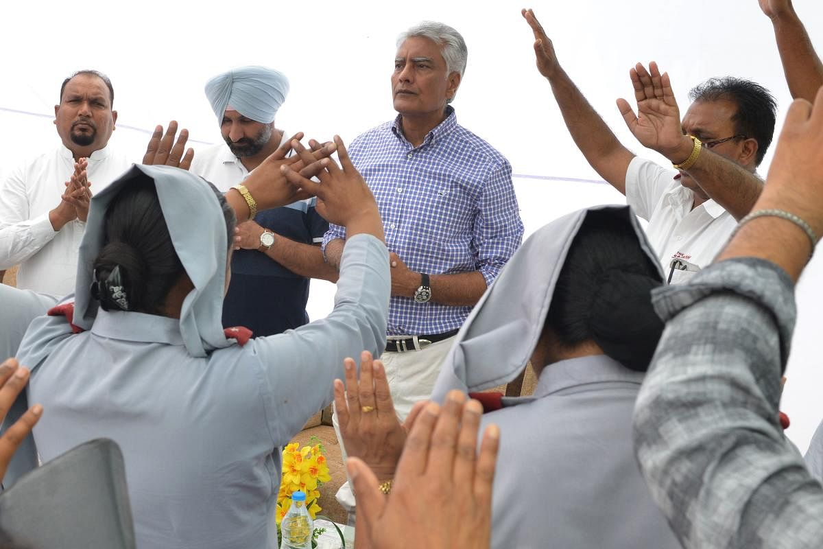 Indian National Congress party Punjab president and candidate for Gurdaspur Sunil Kumar Jakhar (C) along with Christians priests offer prayers as he campaigns ahead of the Lok Sabha election at the Salvation Army Central Corps. (Photo by AFP)