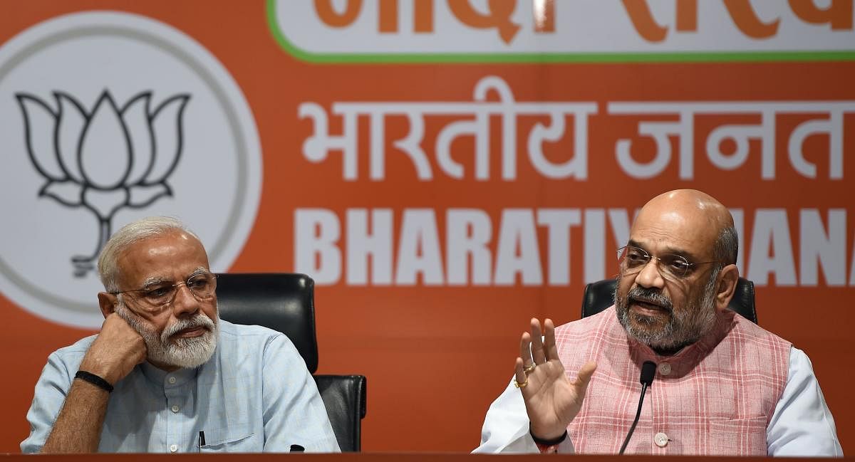 Prime Minister Narendra Modi (L) and Bharatiya Janata Party president Amit Shah take part in a press conference in New Delhi on May 17, 2019. - Indian Prime Minister Narendra Modi on May 17 condemned an extremist Hindu election candidate from his ruling p