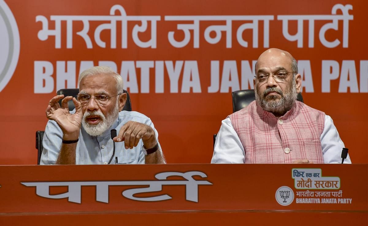 Prime Minister Narendra Modi speaks as BJP President Amit Shah looks on during a press conference at the party headquarter in New Delhi, Friday, May 17, 2019. (PTI Photo)