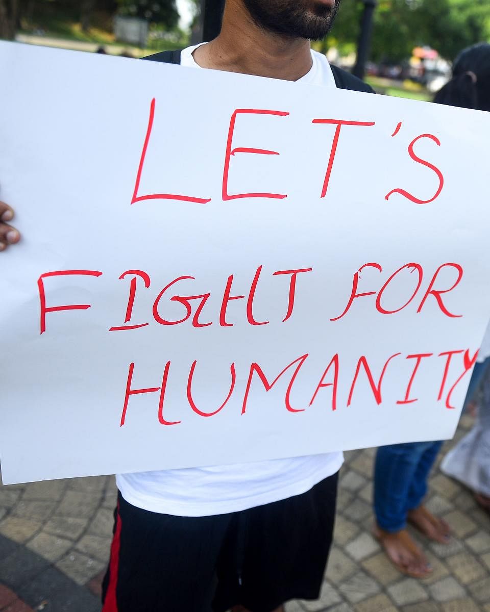 Sri Lankan militants hold placards as they demonstrate against the anti-Muslim mob attacks in Colombo on May 16, 2019. - Sri Lanka's army on May 16 denied allegations that its troops colluded with anti-Muslim mobs and failed to contain widespread riots th
