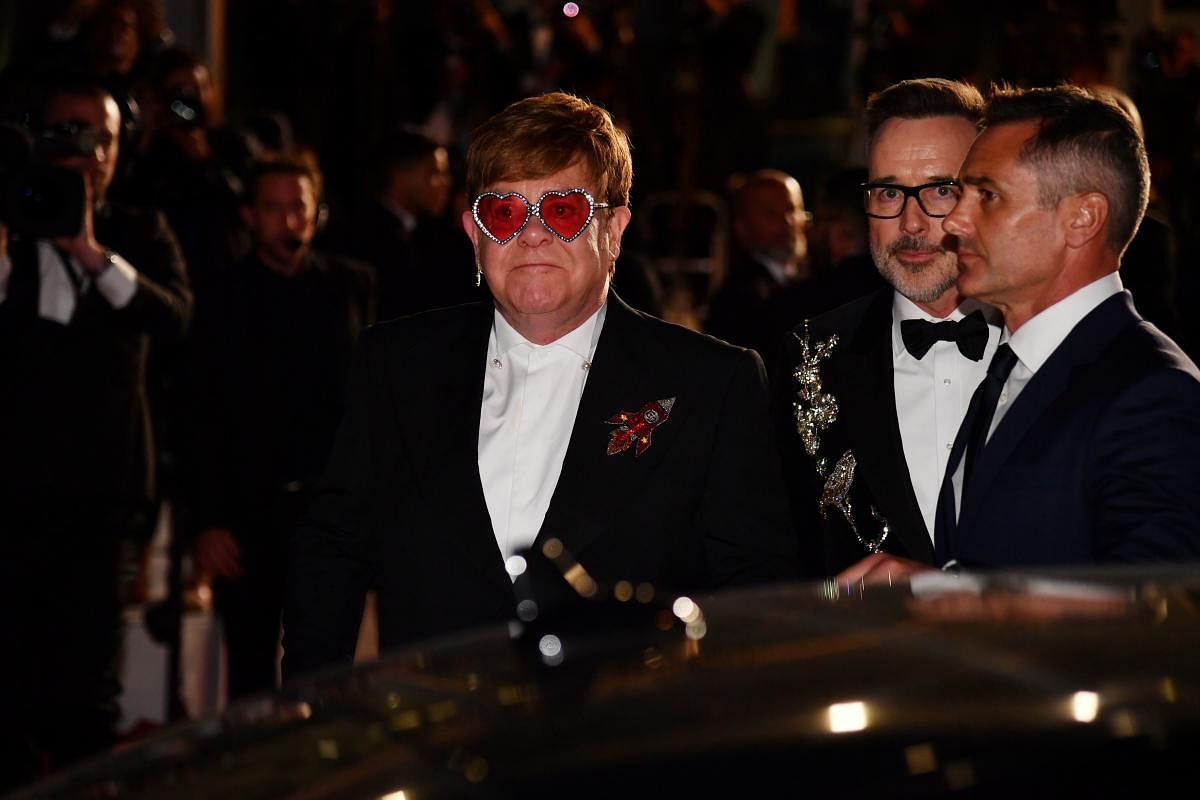 British singer-songwriter Elton John (L) and his husband Canadian producer David Furnish (C) leave after attending the screening of the film "Rocketman" at the 72nd edition of the Cannes Film Festival in Cannes, southern France. AFP