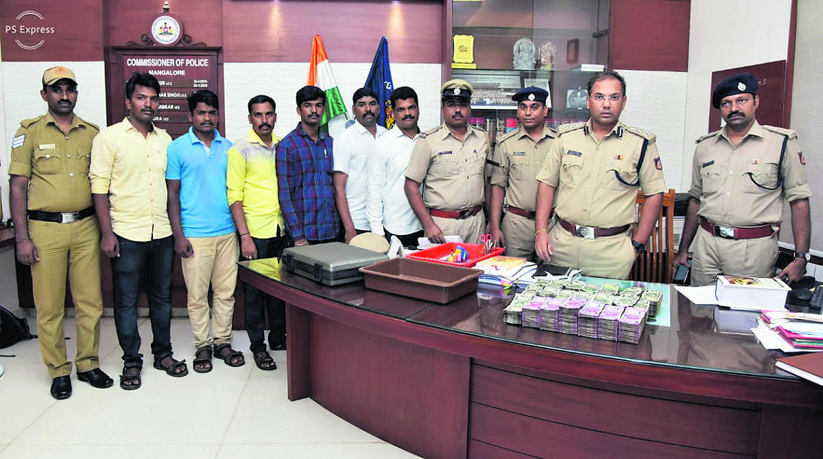 Mangaluru City Police Commissioner Sandeep Patil along with police personnel and the cash seized.