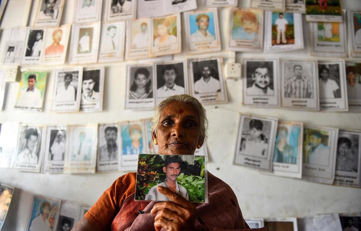 A Sri Lankan Tamil woman holds a picture of a missing loved one at the Missing people organization office in the district of Mullaittivu on May 17, 2019, ahead of the 10th anniversary of Sri Lankan troops defeating Tamil Tiger rebels and declaring an end