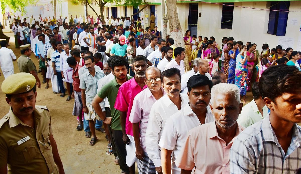  Voters wait in queues to cast their votes at a polling station, during the by-election for Thiruparankundram Assembly seat, in Madurai on Sunday. PTI photo