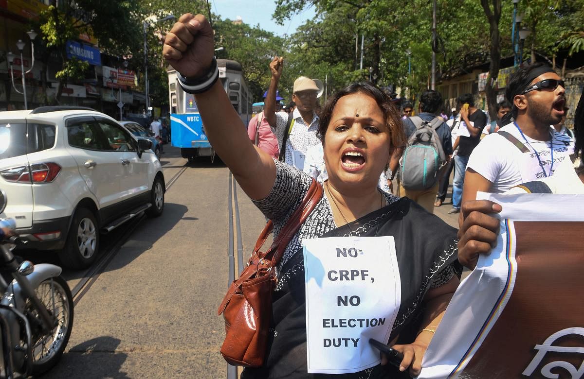 Indian school teachers selected as polling station officials shout slogans against the government and election commission as they demand security forces be posted at voting booths to ensure safety in the upcoming general election in Kolkata on April 8, 20