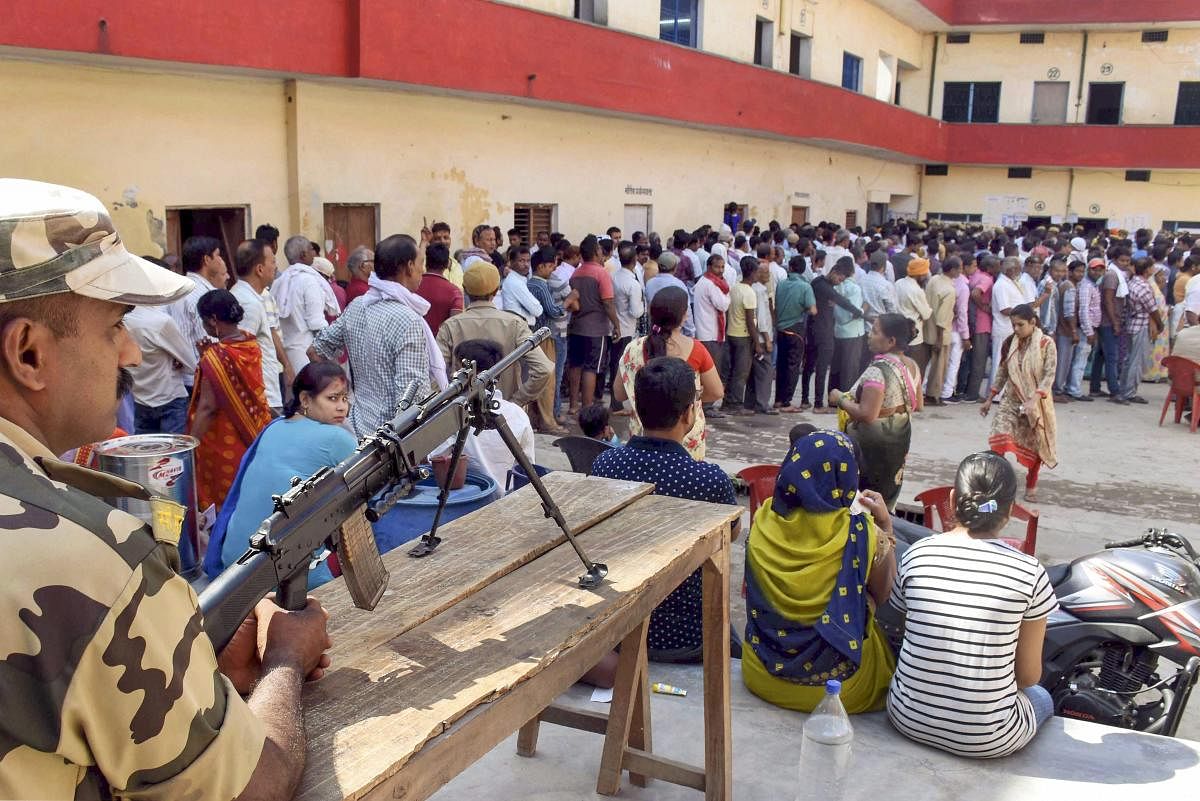  A security personnel stands guard outside a polling station during the seventh and last phase of Lok Sabha elections in Varanasi on Sunday. PTI photo