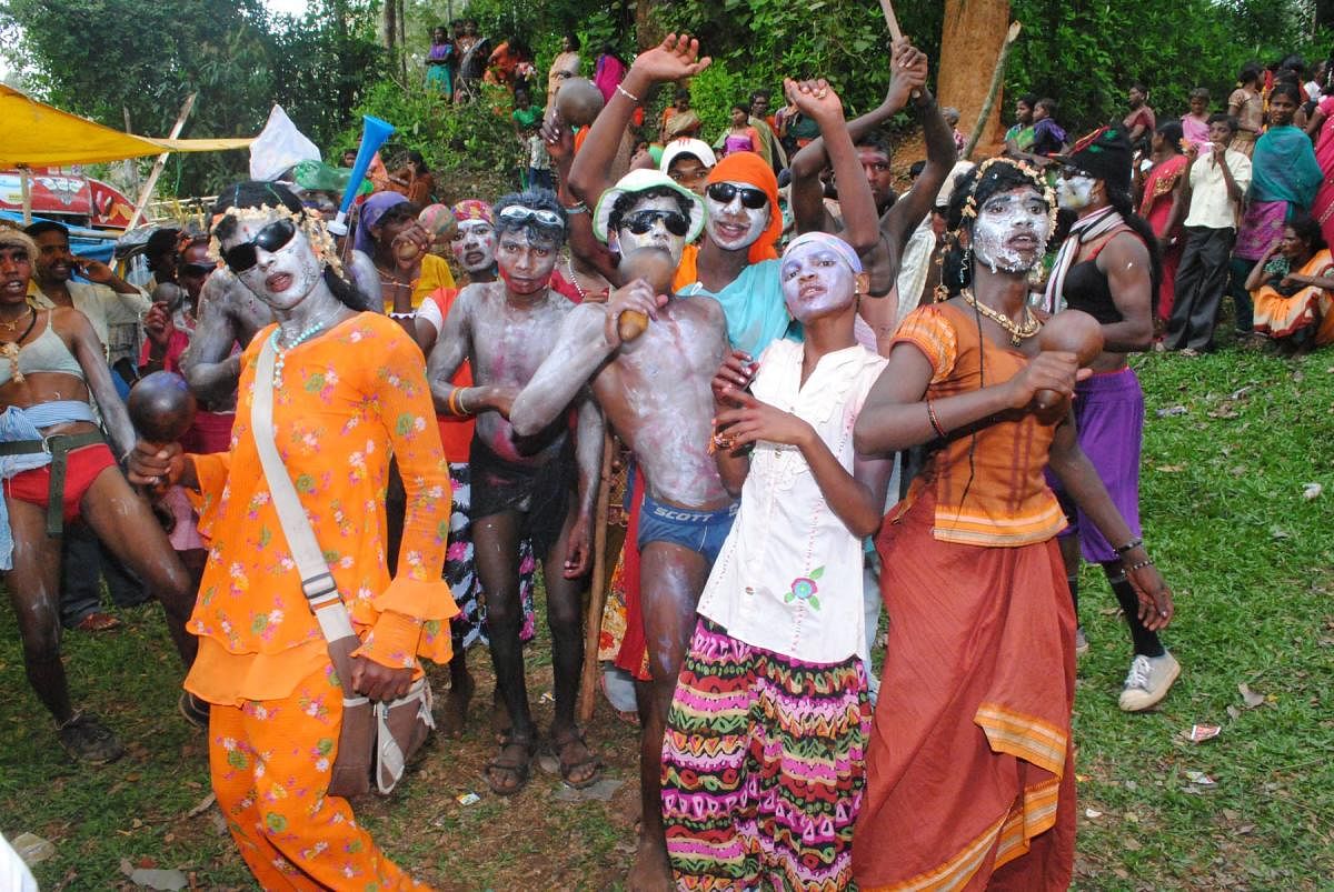 Men wearing weird makeup and costumes dance on the occasion of 'Kunde Habba'.