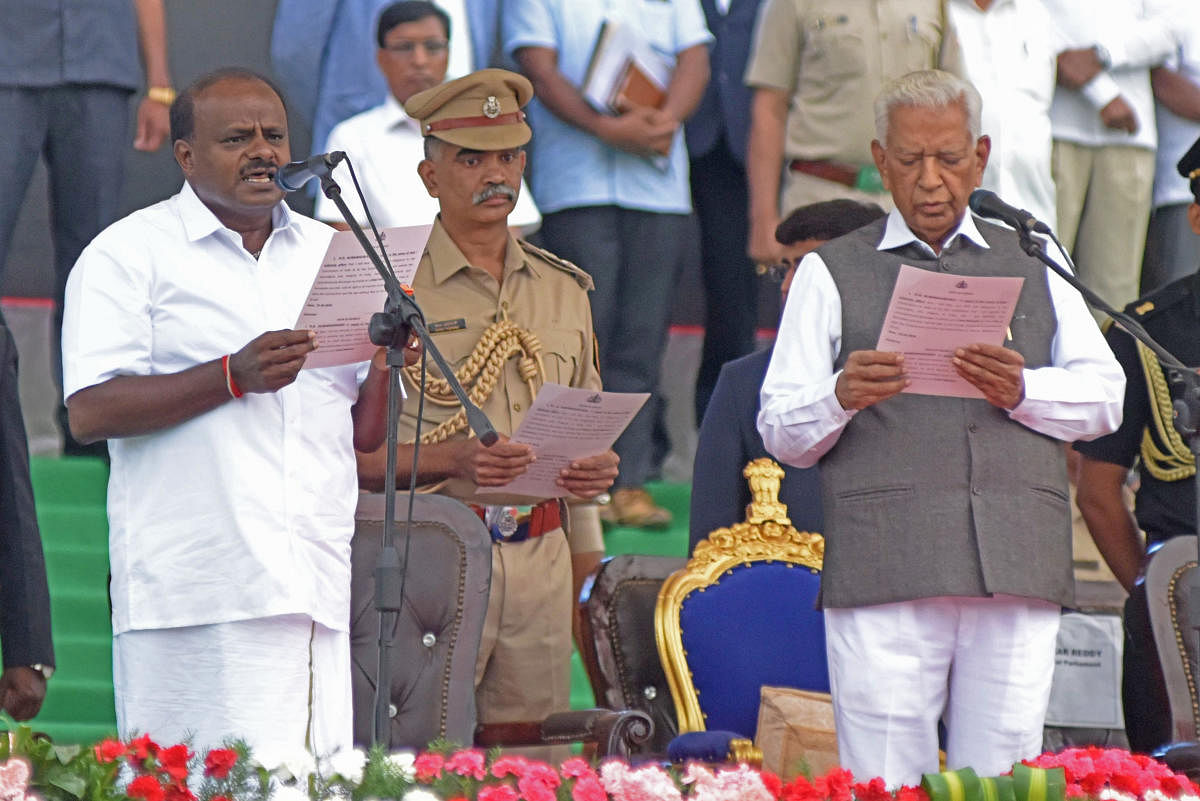 Vajubhai Vala, Governor of Karnataka administer the oath of office and secrecy to new Chief Minister JD(S) leader H D Kumaraswamy at Grand steps of Vidhana Soudha in Bengaluru on Wednesday. Photo by S K Dinesh