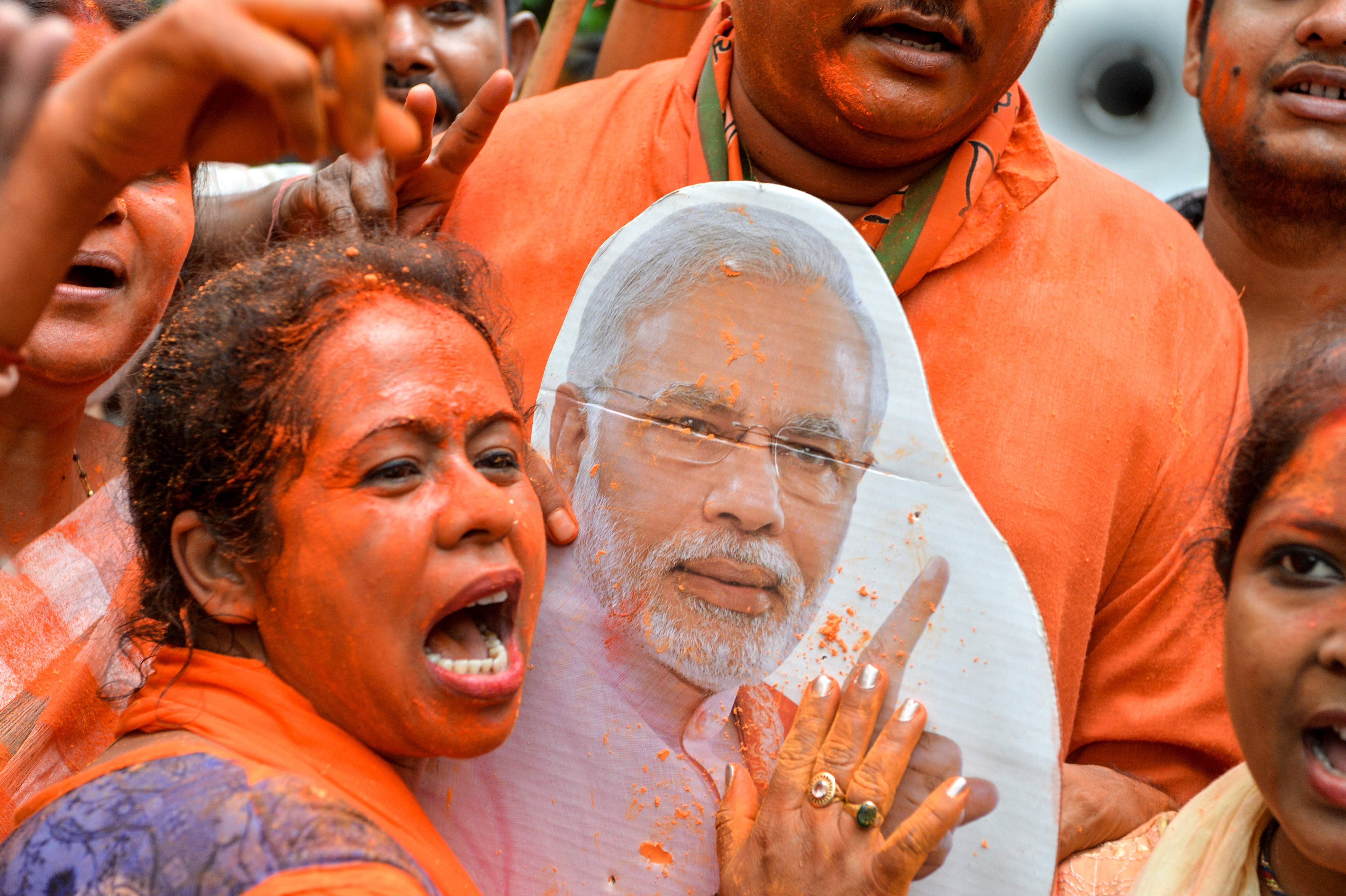A Bharatiya Janata Party supporter shouts slogans with a cut-out of Indian Prime Minister Narendra Modi as she celebrates the election results in Siliguri on May 23, 2019. Credit: Diptendu Dutta/AFP