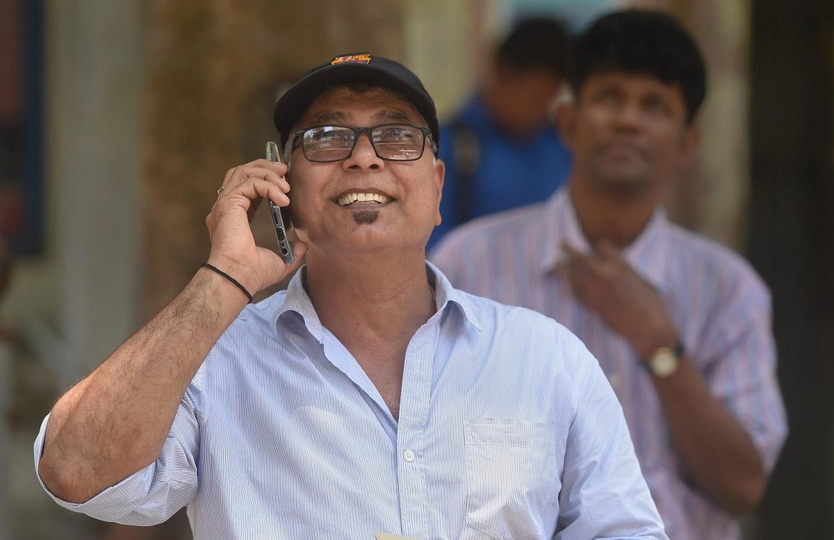 A man talks over phone while watching the stock prices on a digital screen at the BSE building in Mumbai on May 20, 2019. PTI 